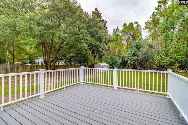 deck with a lawn and a storage shed