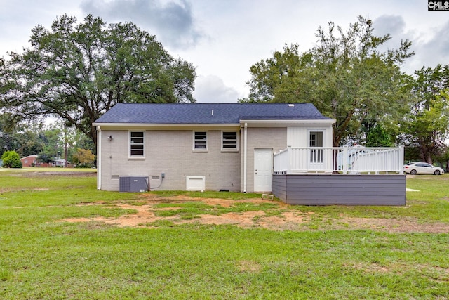 back of property with central AC unit, a wooden deck, and a yard