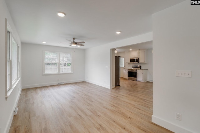 unfurnished living room with ceiling fan and light wood-type flooring