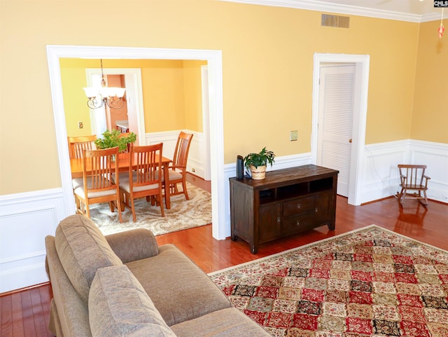 living room with a notable chandelier, crown molding, and hardwood / wood-style floors