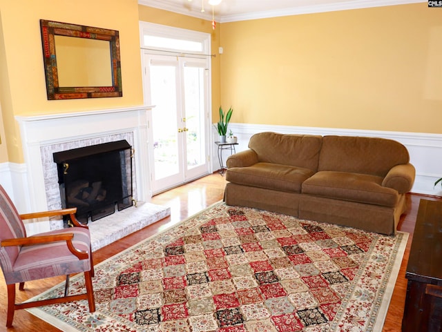 living room featuring french doors, hardwood / wood-style flooring, a fireplace, and ornamental molding