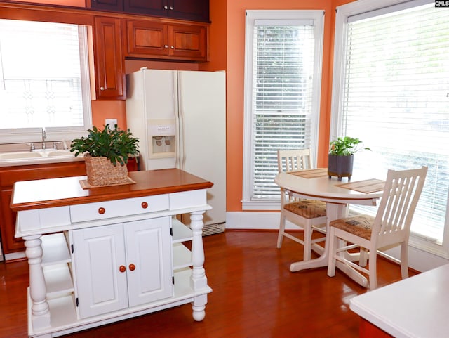 kitchen with white fridge with ice dispenser, dark wood-type flooring, and plenty of natural light