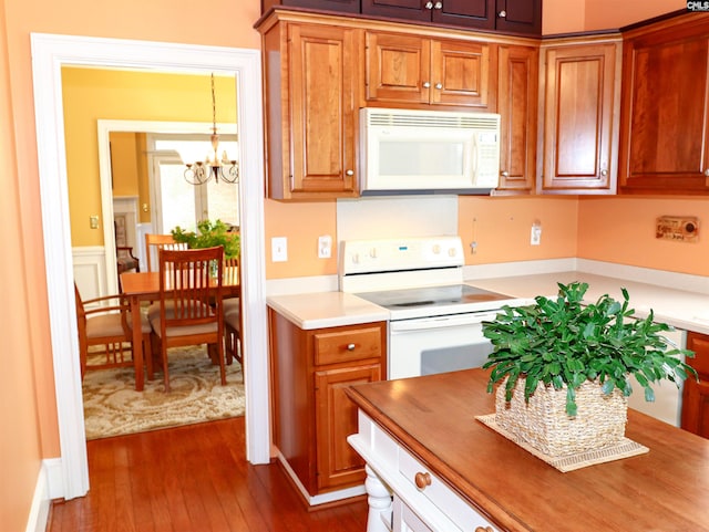 kitchen featuring white appliances, dark wood-type flooring, and a chandelier