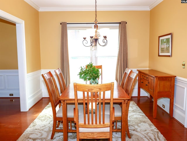 dining area with an inviting chandelier, crown molding, and hardwood / wood-style floors