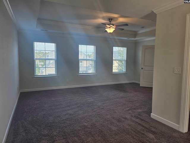 carpeted spare room featuring a tray ceiling, ceiling fan, and crown molding