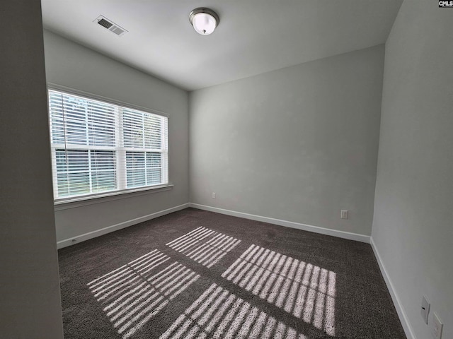 empty room with dark colored carpet