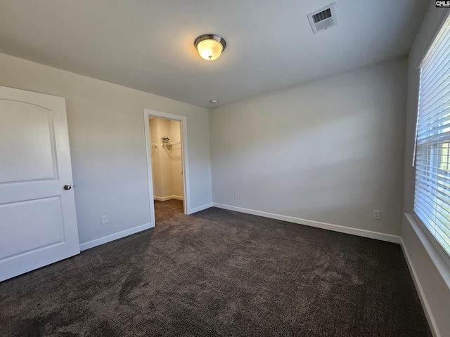 unfurnished room with dark colored carpet