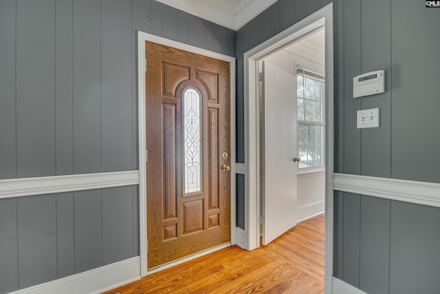 foyer entrance with crown molding and light hardwood / wood-style floors