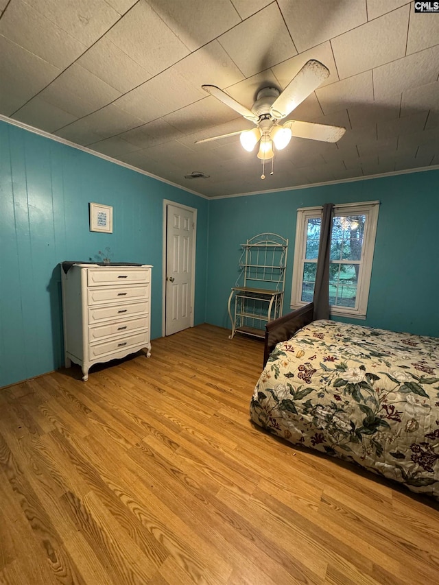 bedroom featuring ceiling fan, ornamental molding, and light hardwood / wood-style floors