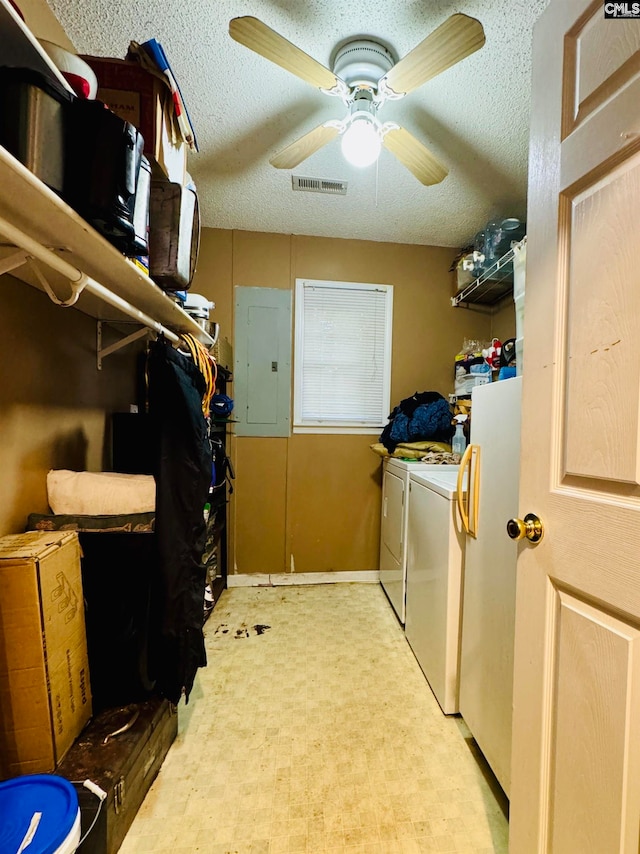 clothes washing area featuring ceiling fan, electric panel, separate washer and dryer, and a textured ceiling