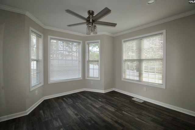 spare room with dark wood-style flooring, baseboards, crown molding, and a ceiling fan