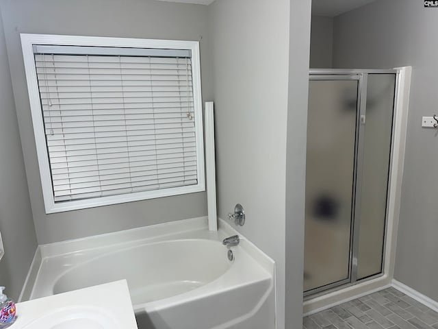 bathroom featuring shower with separate bathtub