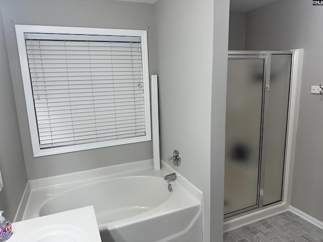 bathroom featuring a stall shower and a garden tub