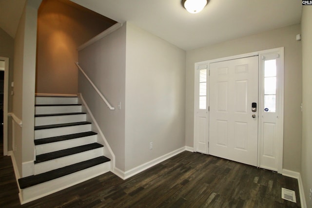 entrance foyer with dark wood finished floors, baseboards, and stairway