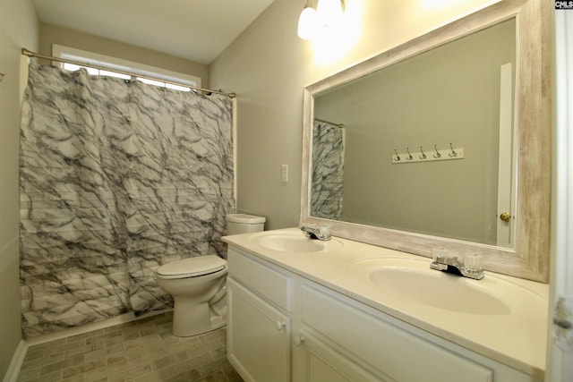 bathroom with curtained shower, vanity, and toilet