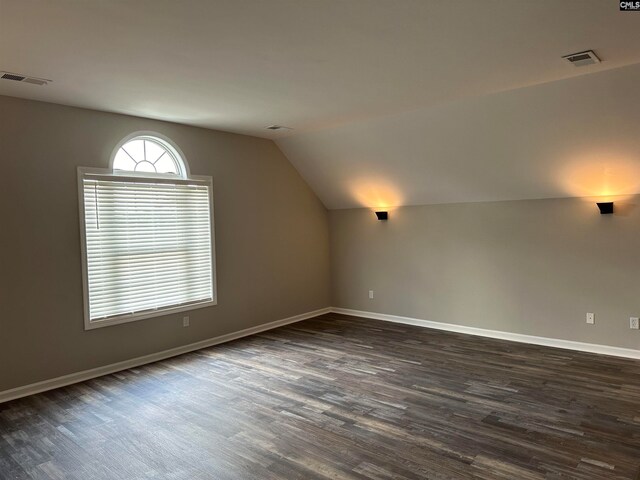 additional living space featuring lofted ceiling and dark wood-type flooring