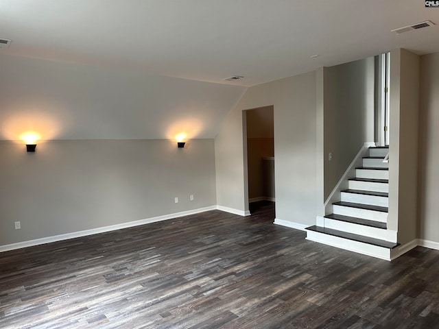 empty room with lofted ceiling and dark wood-type flooring