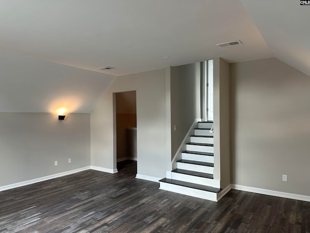 interior space featuring vaulted ceiling and dark wood-type flooring