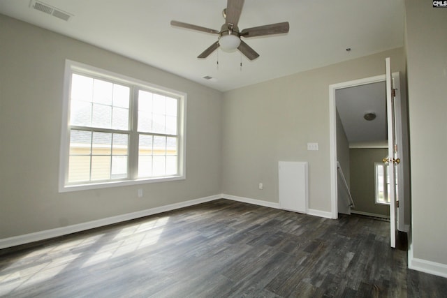 unfurnished room with dark wood finished floors, plenty of natural light, ceiling fan, and baseboards