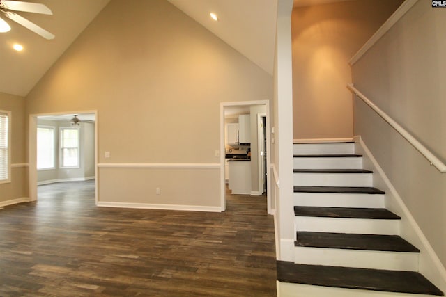 stairway with ceiling fan, hardwood / wood-style floors, and high vaulted ceiling