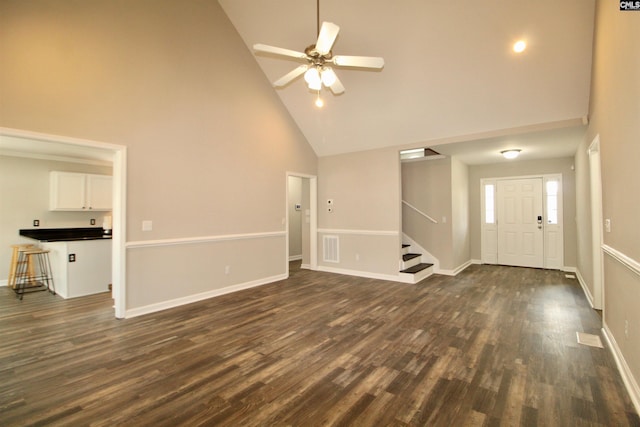 unfurnished living room featuring high vaulted ceiling, stairs, a ceiling fan, dark wood-style floors, and baseboards