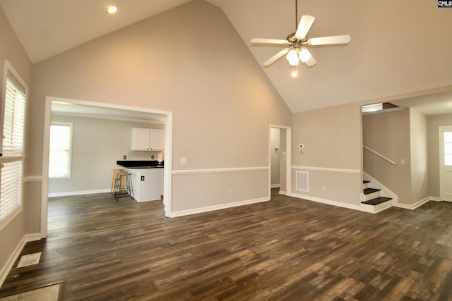 unfurnished living room featuring ceiling fan, dark wood-type flooring, and high vaulted ceiling