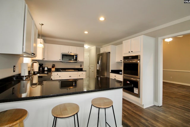 kitchen with stainless steel appliances, white cabinets, decorative light fixtures, and dark hardwood / wood-style flooring