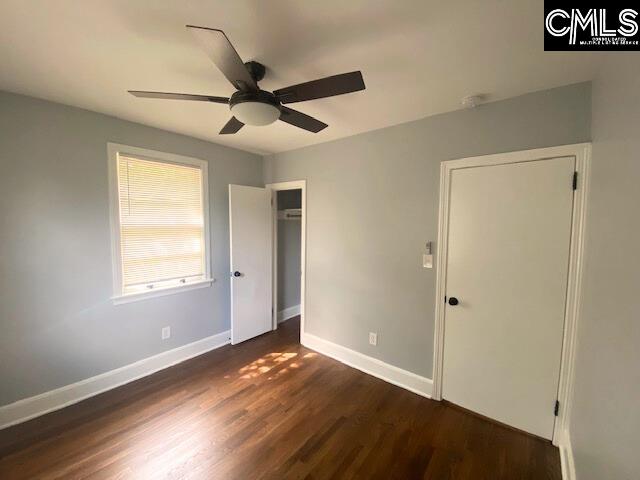 unfurnished bedroom featuring ceiling fan and dark hardwood / wood-style floors