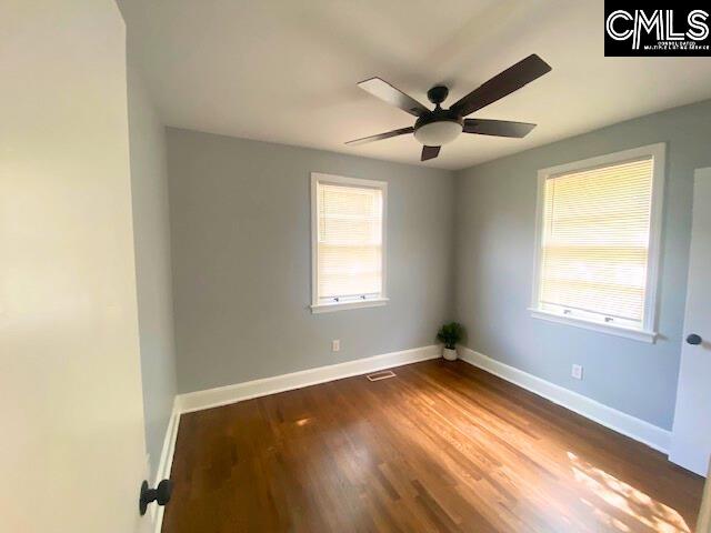 empty room featuring ceiling fan and dark wood-type flooring