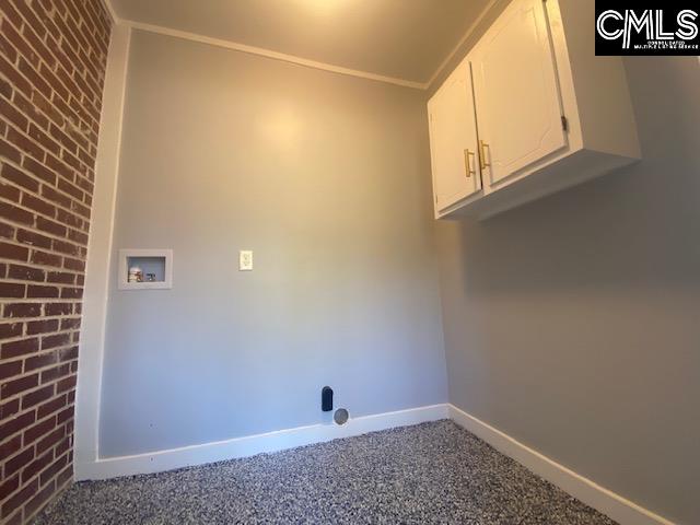 clothes washing area with hookup for a washing machine, brick wall, carpet flooring, and cabinets