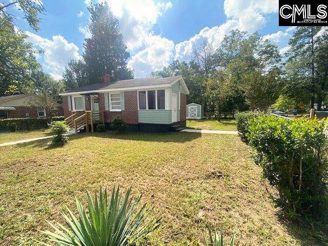 view of front of property with a shed and a front yard