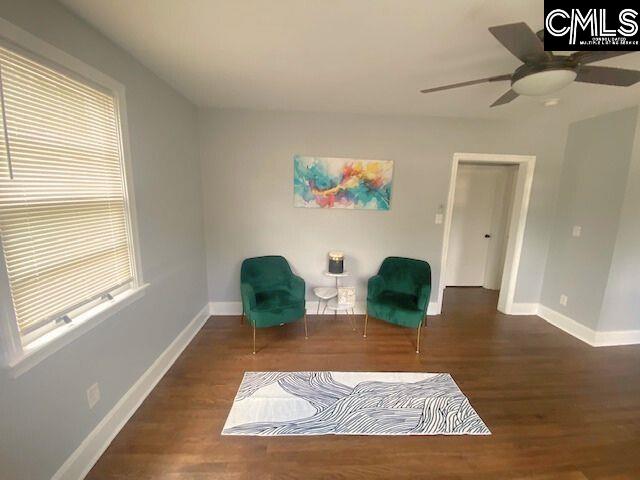 sitting room featuring ceiling fan and dark wood-type flooring