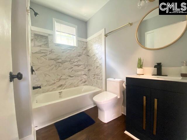 full bathroom featuring tiled shower / bath combo, vanity, toilet, and wood-type flooring