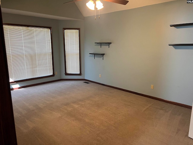 carpeted spare room with vaulted ceiling and ceiling fan