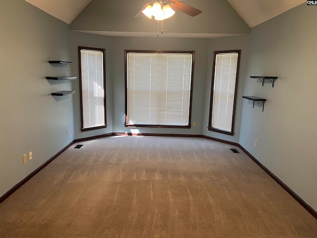 spare room with ceiling fan, light colored carpet, and vaulted ceiling