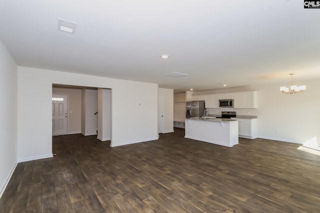 kitchen with an island with sink, appliances with stainless steel finishes, dark hardwood / wood-style floors, and sink