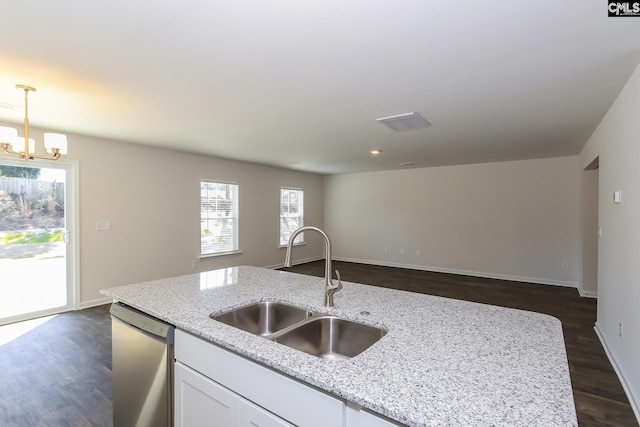 kitchen featuring light stone countertops, dishwasher, pendant lighting, and sink