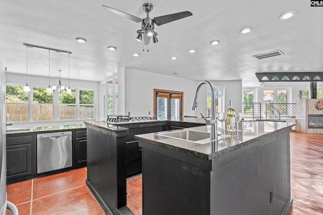 kitchen with a kitchen island with sink, dishwasher, sink, and decorative light fixtures