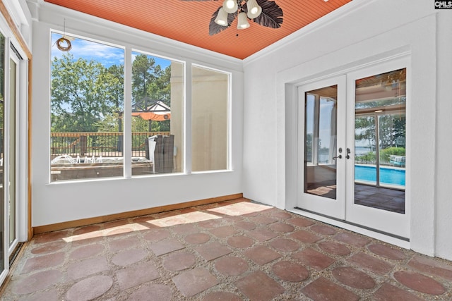 unfurnished sunroom featuring a healthy amount of sunlight, wood ceiling, and french doors