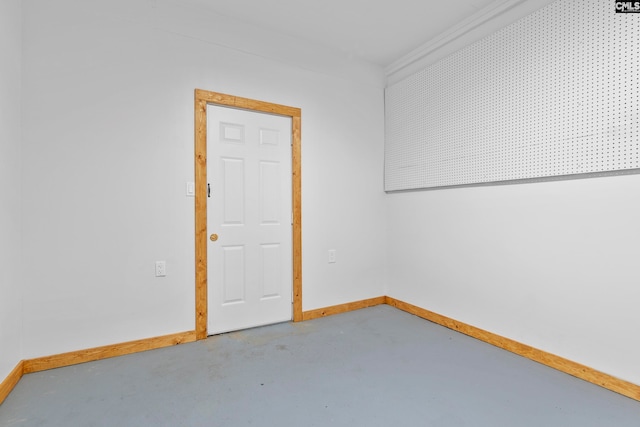 spare room featuring ornamental molding and concrete floors