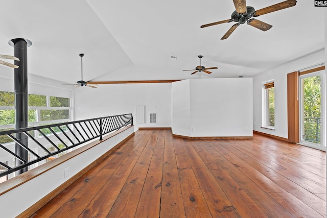 empty room with lofted ceiling, hardwood / wood-style floors, and ceiling fan