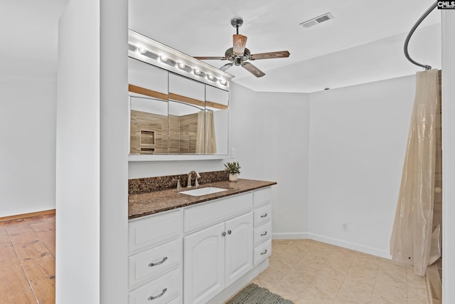 bathroom featuring ceiling fan, vanity, and curtained shower