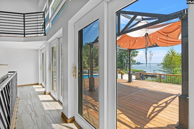 doorway featuring a water view, light hardwood / wood-style floors, and french doors