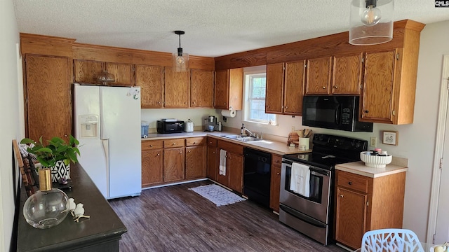 kitchen with decorative light fixtures, black appliances, dark wood-type flooring, and a textured ceiling