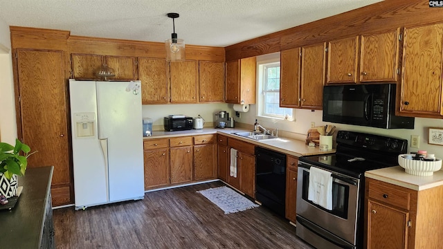 kitchen featuring dark hardwood / wood-style floors, sink, black appliances, decorative light fixtures, and a textured ceiling