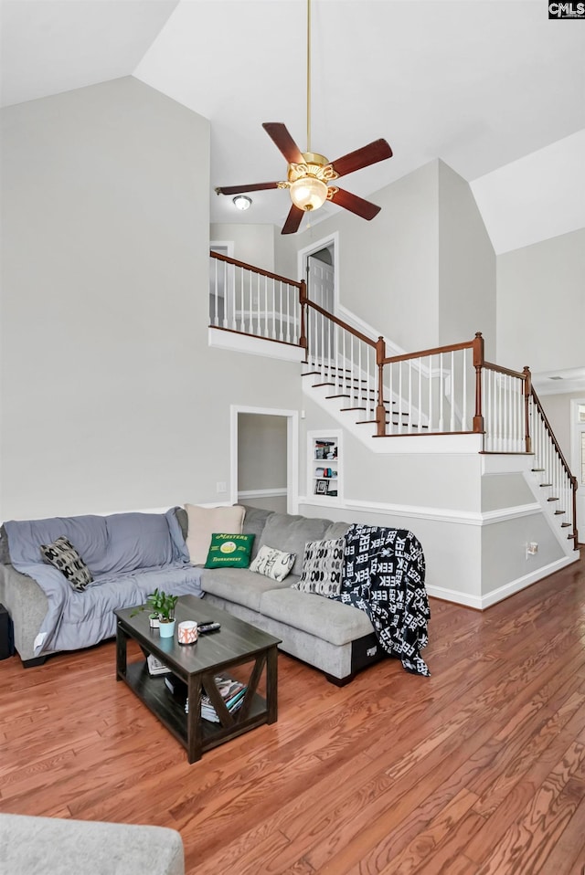 living room with ceiling fan, hardwood / wood-style flooring, and high vaulted ceiling