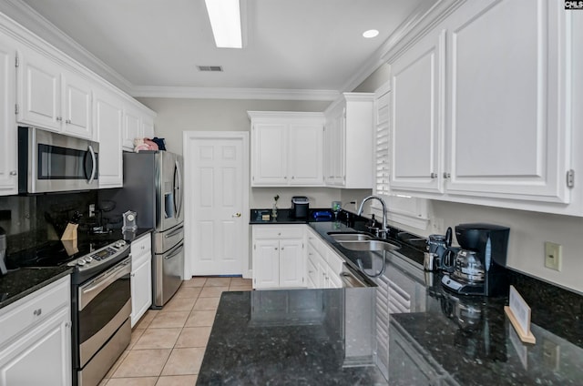 kitchen with appliances with stainless steel finishes, crown molding, light tile patterned flooring, and white cabinets