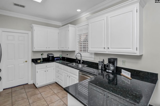 kitchen with light tile patterned flooring, ornamental molding, sink, stainless steel dishwasher, and white cabinetry