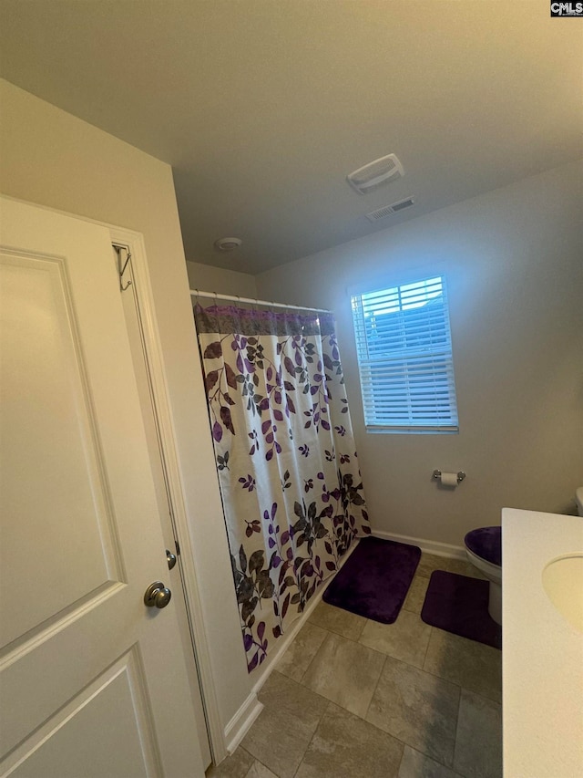 bathroom with vanity, toilet, and curtained shower