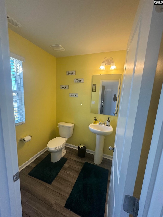 bathroom with hardwood / wood-style floors and toilet